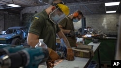 Engineers of design and production bureau "UkrPrototyp" work on new parts for a ground drone, in northern Ukraine, June 27, 2024.