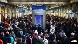 Passengers wait for news of Eurostar departures at St Pancras station in London, Dec. 30, 2023, as services are disrupted due to flooding. 