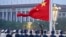 FILE - A Chinese honor guard unfurls the Chinese national flag in Beijing, Oct. 1, 2022. Several Western democracies are working to restart diplomatic engagement with China, while also defending their own countries' interests.