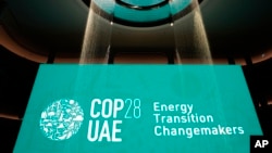 FILE - In a display, h2o  flows onto a motion   for Energy Transition Changemakers astatine  the COP28 U.N. Climate Summit, successful  Dubai, United Arab Emirates, Dec. 5, 2023.