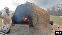 A woodburning fire heats the inside of this replica of an 18th-century-style clay oven that Justin Cherry uses to bake the bread. Known as a beehive, ovens like this were commonplace in households in the 1700s. (Deborah Block/VOA)