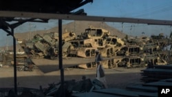 Destroyed Humvess used by the US Army during the war against the Taliban in Afghanistan are seen stacked to be sold as scrap metal in Kandahar City, Afghanistan, June 12, 2023.