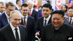 ARCHIVO - El presidente ruso, Vladimir Putin, a la izquierda, y el líder de Corea del Norte, Kim Jong Un, sonríen mientras caminan después de las conversaciones en Pyongyang, Corea del Norte, el 19 de junio de 2024. (Foto del Kremlin vía AP)