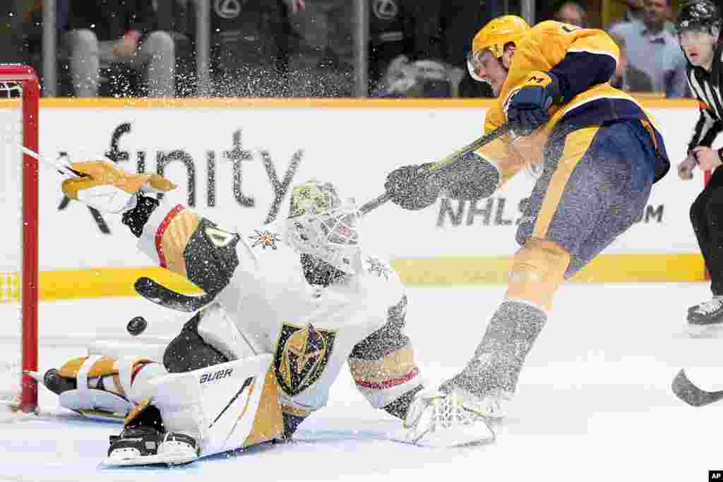 Vegas Golden Knights goaltender Jiri Patera (30) deflects a shot on goal by Nashville Predators defenseman Tyson Barrie, right, during the second period of an NHL hockey game, March 26, 2024, in Nashville, Tennessee.