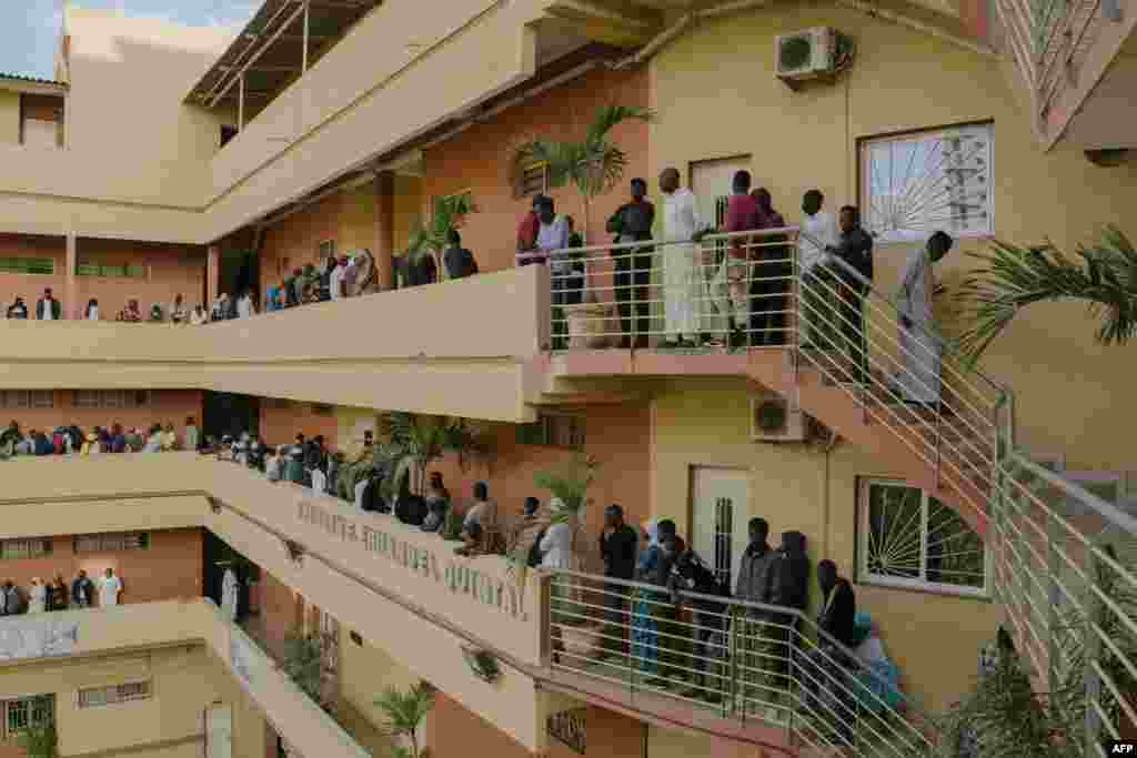 People form a line to vote at a polling station in a school in downtown Dakar, March 24, 2024, during the Senegalese presidential elections.