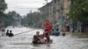 Warga setempat melintasi jalanan yang tergenang banjir setelah hujan lebat di wilayah Bago, Myanmar. (AFP)&nbsp;