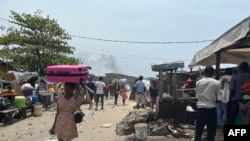 Des habitants portent leurs affaires après la démolition d'une partie du quartier de Jakande à Lagos, le 14 mars 2024. 