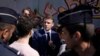 French President Emmanuel Macron, center, meets with residents during a visit focusing on security and the fight against drug trafficking, in La Castellane district of Marseille, southeastern France, on March 19, 2024. 