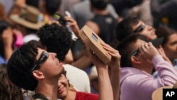 People use special glasses to watch a total solar eclipse in Mazatlan, Mexico, April 8, 2024. 