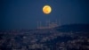 FILE - A full moon rises behind the Camlica mosque in Istanbul, Turkey, Feb. 24, 2024. 