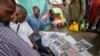 People discuss Saturday's election as they look at newspapers from a street vendor at an intersection in Lagos, Nigeria on Feb. 26, 2023.