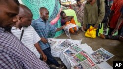 নাইজেরিয়ার লাগোসের একটি মোড়ে, হকারের কাছ থেকে সংবাদপত্র নিয়ে দেখার সময় লোকজন শনিবারের নির্বাচন নিয়ে আলোচনা করছে। ২৬ ফেব্রুয়ারি, ২০২৩।