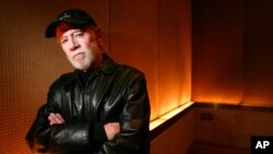 FILE - Actor and comedian George Carlin poses in a New York hotel, March 19, 2004. Carlin's estate is suing a media company over an hour-long special which uses a synthesis of the late comedian to deliver commentary on current events.