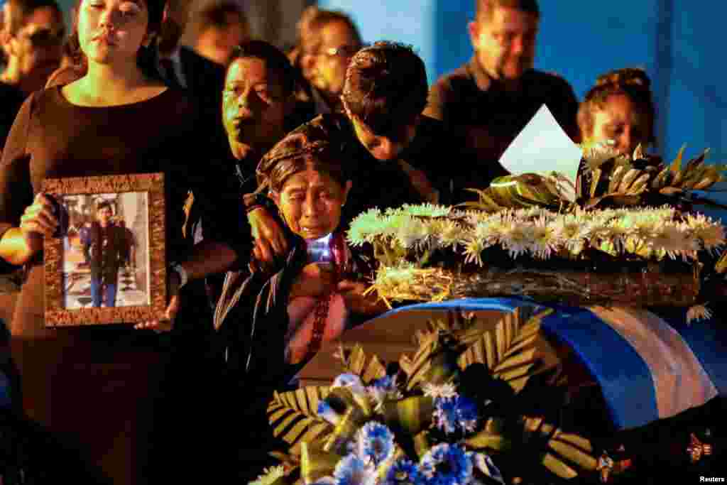 Relatives of migrants who died during a fire at a migrant detention center in the Mexican border city of Ciudad Juarez, react as caskets carrying the bodies arrive in a Mexican Air Force plane, at La Aurora International Airport, in Guatemala City, Guatemala, April 11, 2023.&nbsp;