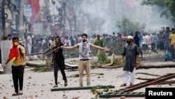 A demonstrator gestures as protesters clash with Border Guard Bangladesh (BGB) and the police outside the state-owned Bangladesh Television as violence erupts across the country after anti-quota protests by students, in Dhaka, Bangladesh, July 19, 2024. 