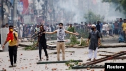 FILE - A demonstrator gestures as protesters clash with Border Guard Bangladesh and the police outside the state-owned Bangladesh Television as violence erupts across the country after anti-quota protests by students, in Dhaka, Bangladesh, July 19, 2024. 