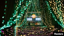 A shopkeeper waits for customers at a stall inside a shopping mall with light decorations installed ahead of the Ramadan festive in Jakarta, Indonesia, March 20, 2023.