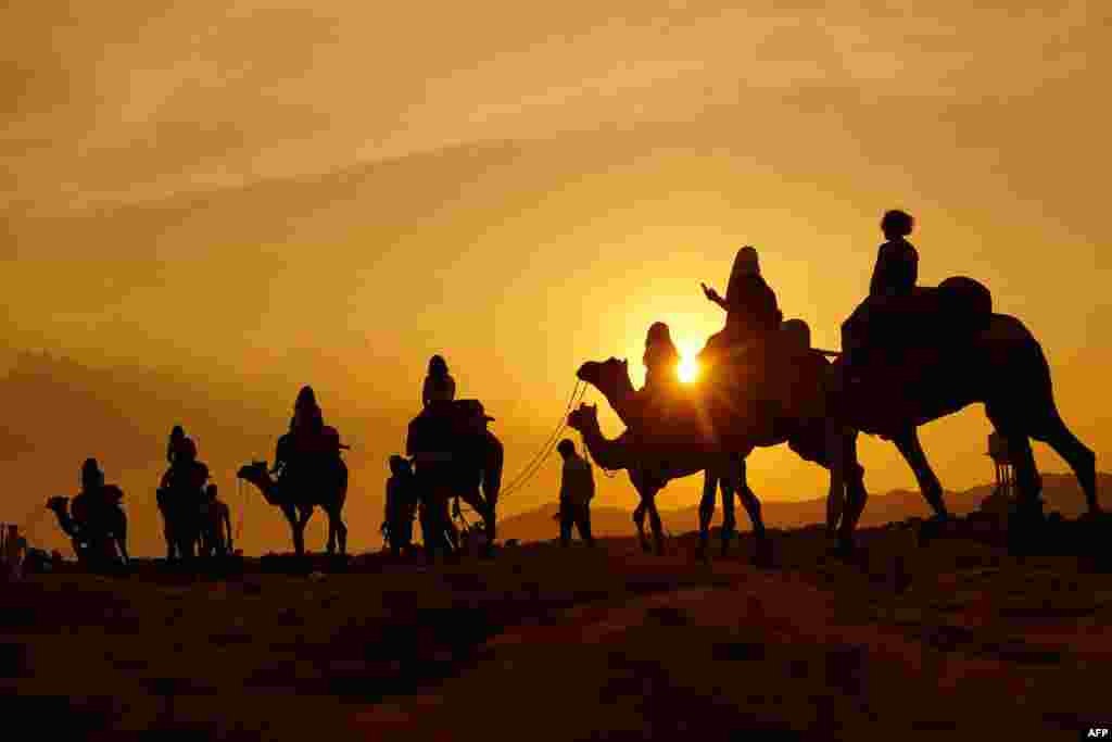 Tourists enjoy a camel safari at a desert in Pushkar, India.