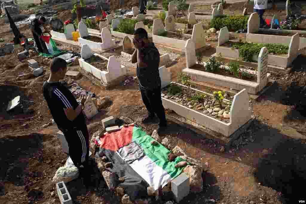 Jóvenes palestinos oran por sus muertos más recientes, los que cayeron durante la última incursión del Ejército de Israel en el campo de refugiados de Nur Shams, en Tulkarem, Cisjordania.