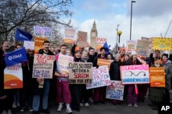 Junior doctors hold placards as they stand at a picket line outside St. Thomas' Hospital in Westminster in London, March 13, 2023.