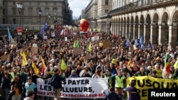 Para pengunjuk rasa berjalan melewati museum Louvre di Rue de Rivoli dalam aksi unjuk rasa hari ke-12 dan protes terhadap reformasi pensiun pemerintah Prancis, di Paris, 13 April 2023. (REUTERS/Stephanie Lecocq)