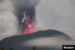 Petir muncul di tengah badai saat Gunung Ibu memuntahkan material vulkanik saat terjadi letusan, terlihat dari Gam Ici di Halmahera Barat, Maluku Utara, 18 Mei 2024. (Foto: via Reuters)