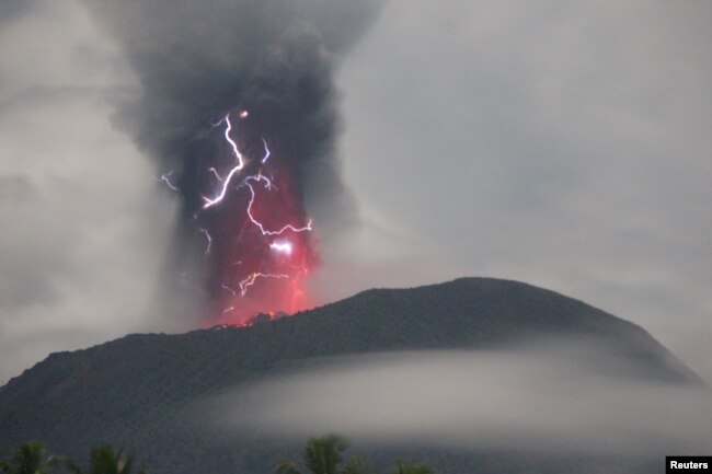 Petir muncul di tengah badai saat Gunung Ibu memuntahkan material vulkanik saat terjadi letusan, terlihat dari Gam Ici di Halmahera Barat, Maluku Utara, 18 Mei 2024. (Foto: via Reuters)