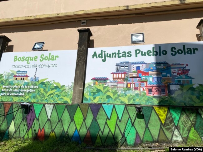 In the solar forest, the community can access energy to charge their devices in an area decorated by local artists. (Salome Ramirez/VOA)