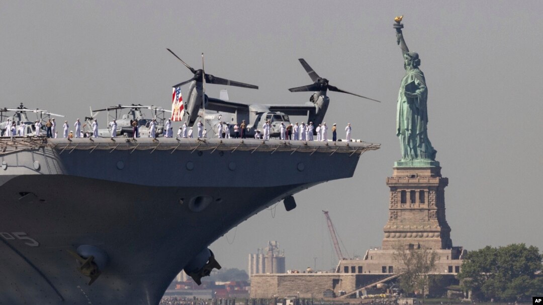 U.S. Sailors and Marines stand on the deck of the USS Bataan as it passes the Statue of Liberty during Fleet Week on in New York, May 22, 2024.