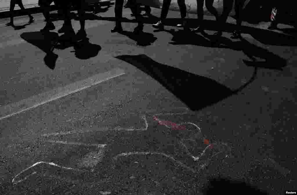 The silhouette of a murdered person is seen, as demonstrators march to demand justice in the death of Maximo Jerez, an 11-year-old who was killed Sunday, when at least one gunman attacked a birthday party, as the National Government deployed forces to help control escalating violence in Rosario, in Santa Fe province, Argentina.