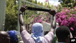 A protester holds up a machete as a symbol of self-defense against gangs, during a protest against insecurity in Port-au-Prince, Haiti, Aug. 25, 2023.