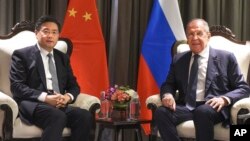 In this photo released by China's Xinhua News Agency, Chinese Foreign Minister Qin Gang, left, and Russian Foreign Minister Sergei Lavrov meet on the sidelines of the Shanghai Cooperation Organization (SCO) foreign ministers' meeting in Goa, India, May 4, 2023.