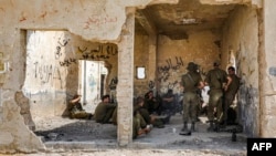FILE - Israeli soldiers gather inside an old Jordanian-built building during a training near an Israeli military camp by the village of Yatta in the south of the occupied West Bank, Sept. 16, 2020.