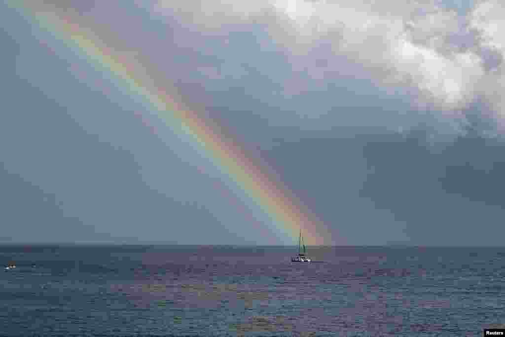 A rainbow appears after a heavy rainfall as a catamaran sails in Adriatic sea, seen from the town of Bol at the island of Brac, Croatia, Aug. 30, 2023.