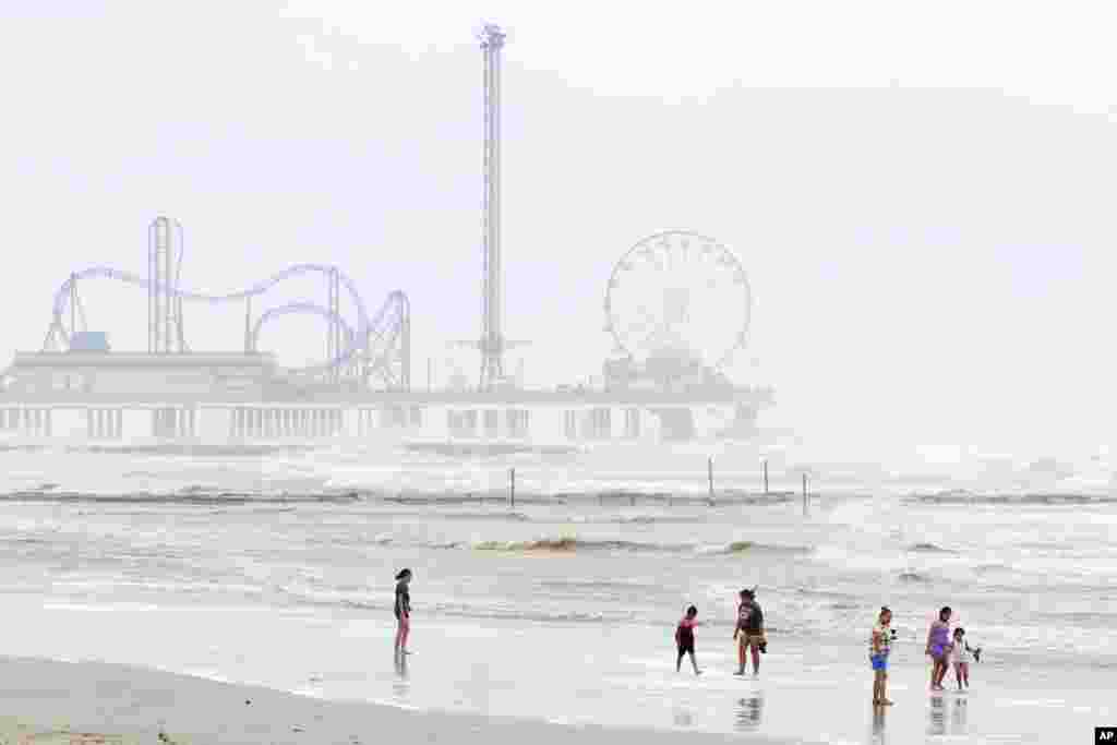 Una familia camina por la playa en medio del oleaje agitado cerca a Pleasure Pier, tras el paso de Beryl el lunes 8 de julio de 2024, en Galveston, Texas.