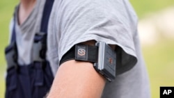 A SlateSafety armband is worn by Wyatt Fischer, a furnace mason employee at Cardinal Glass, Thursday, Aug. 22, 2024, in Menomonie, Wis. (AP Photo/Abbie Parr)