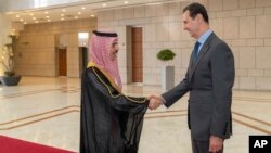 FILE - In this photo released by the Syrian official news agency SANA, Syrian President Bashar Assad, right, welcomes Saudi Minster of Foreign Affairs Faisal bin Farhan, left, ahead of their meeting in Damascus, Syria, April 18, 2023.