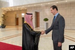 FILE - In this photo released by the Syrian official news agency SANA, Syrian President Bashar Assad, right, welcomes Saudi Minster of Foreign Affairs Faisal bin Farhan, left, before their meeting in Damascus, Syria, April 18, 2023.