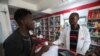 FILE —Sodiq Ajibade, 29, who suffers from bouts of asthma attacks, speaks to a pharmacist about his medication at a pharmacy in Lagos, Nigeria December 11, 2023. 