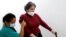 Pilar Redondo Arribas (55), berjalan dengan tongkat dan bantuan fisioterapis saraf Guissela Rodriguez Palomino di Pusat Rehabilitasi Neurologis dan Fisik Casaverde di Navalcarnero, Spanyol, 20 Oktober 2022. (REUTERS/Susana Vera)