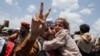 A freed prisoner gestures while holding a child after arriving at Sanaa Airport on an International Committee of the Red Cross (ICRC)-chartered plane, amid a prisoner swap between two sides in the Yemen conflict, in Sanaa, Yemen, April 14, 2023.