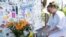Meagan Bryon of Hoboken, New Jersey, places a 'lost shaker of salt' at an impromptu memorial for Jimmy Buffett outside the Shrimpboat Sound recording studio, Sept. 2, 2023, in Key West, Florida. (Rob O'Neal/Florida Keys News Bureau via AP)