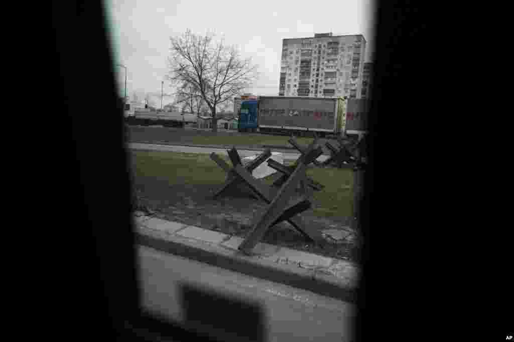 Barreras antitanque metálicas en una calle en Kiev, Ucrania, el 27 de febrero de 2023. Hay sacos de arena protegiendo estatuas y barreras antitanque en las calles, trincheras en los bosques cercanos y avisos de minas terrestres en el monte. Las señales pintadas en las paredes indican el refugio más próximo, mientras las sirenas antiaéreas suenan ocasionalmente en la ciudad, que a veces sufre ataques con misiles.&nbsp;