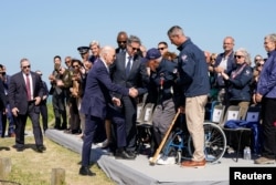 U.S. President Joe Biden shakes hands with WWII veteran John Wardell during a visit to the World War II Pointe du Hoc Ranger Monument following the 80th anniversary of the 1944 D-Day landings in Cricqueville-en-Bessin, Normandy, France, June 7, 2024.