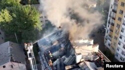 Spasioci i vatrogasci rade na oštećenoj zgradi nakon ruskog raketnog udara, tokom ruske invazije na Ukrajinu, u Lavovu, zapadna Ukrajina, 15. august 2023.