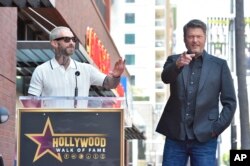 Adam Levine, kiri, memberikan sambutan pada upacara penganugerahan bintang di Hollywood Walk of Fame untuk Blake Shelton, di Los Angeles, Jumat, 12 Mei 2023. (Foto oleh Jordan Strauss/Invision/AP)