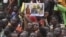 FILE - A man holds a placard with the image of Niger's new military ruler General Abdourahamane Tiani on as people protest outside the Niger and French airbase in Niamey on Sept. 2, 2023 to demand the departure of the French army from Niger.