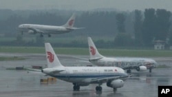 资料照 - 北京国际机场，中国国际航空公司一架飞机正在降落，另外两架正在等待空管的调度准备起飞。