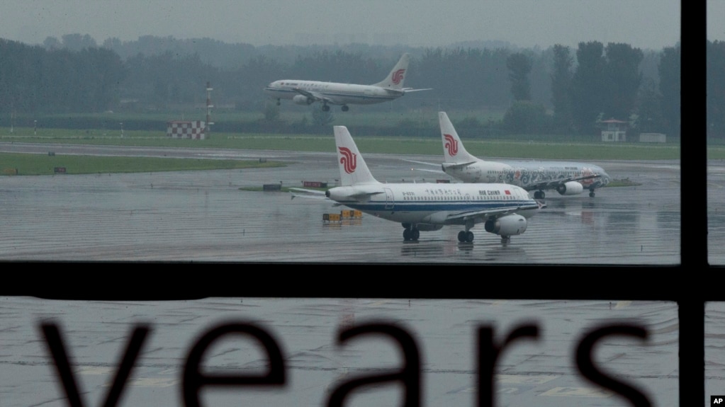 资料照 - 大雨中的北京国际机场。中国国际航空公司一架飞机正在降落，另外两架正在等待空管的调度准备起飞。(photo:VOA)