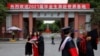 资料照：上海复旦大学学生在校门拍摄毕业照。（2021年6月25日）